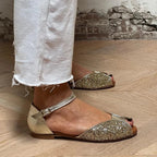 Flache Sandalen mit verstellbarem Knöchelriemen.